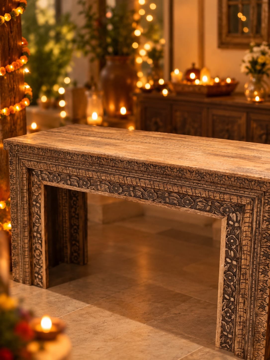 The table on its own: carved sides and a warm wood top, lit only by the room around it.