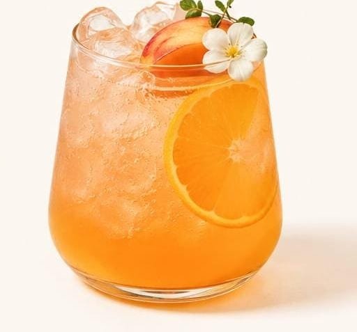 Peach orange yuzu fizz, finished with an orange wheel.