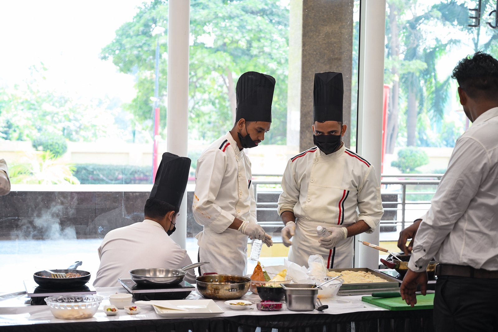 Chefs plating live at the counter, timed to the rhythm of the room, not a fixed kitchen schedule.